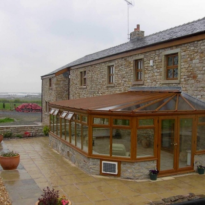 Outside view of a woodgrain uPVC conservatory with rainy outdoors