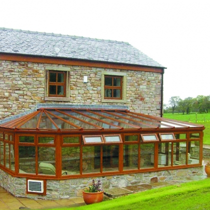 Side view of a woodgrain uPVC conservatory with rainy outdoors