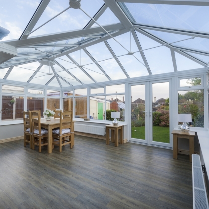 Inside view of a white conservatory with sunny garden