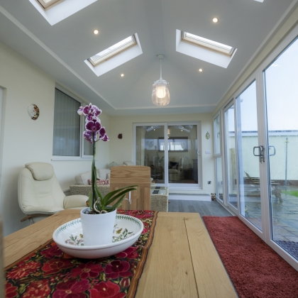 inside view of a conservatory with rainy outdoors and a plant on the table