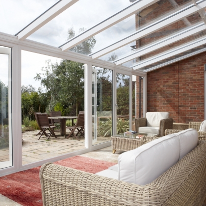 Inside a glazed extension with wicker chairs and table