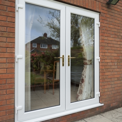 Looking in view through PVCu French doors with curtains