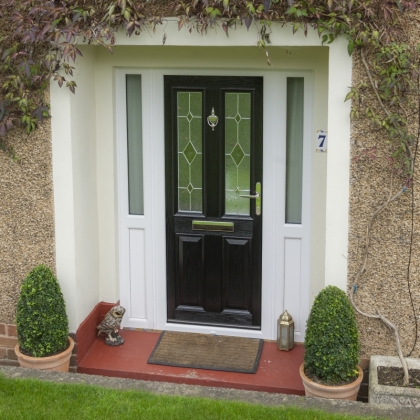 House Number 7 with plants and a black composite front door